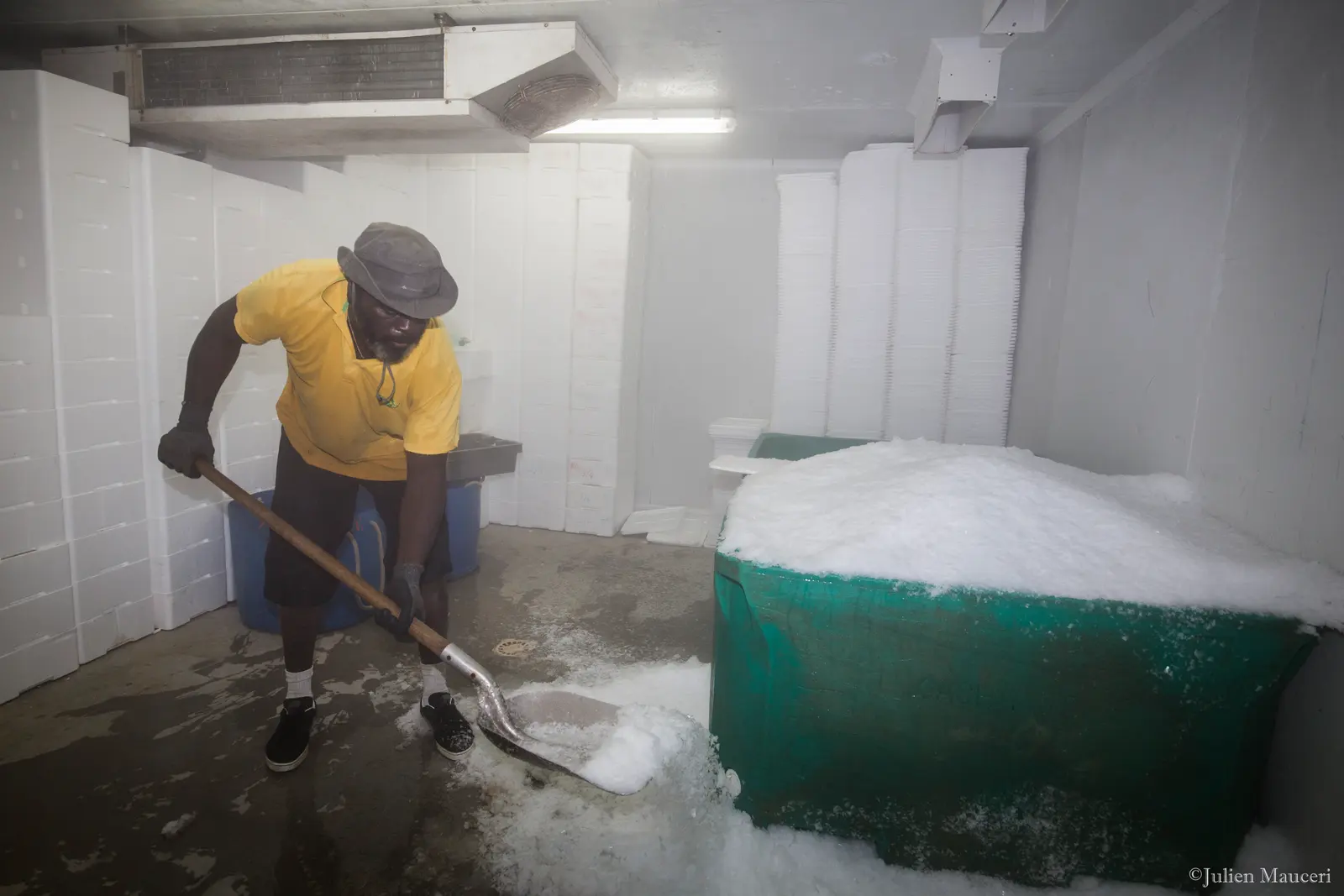 Un employé pelle de la glace dans la chambre froide